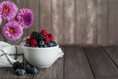 Dut ahududu karışımı. beyaz bir fincan yaban mersini ve böğürtlen