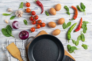 Taze organik maddeler, domates, yumurta, soğan, ıspanak ve biber tava ile ahşap masada