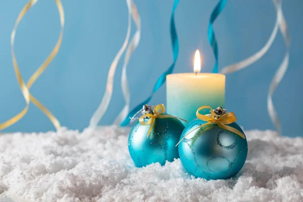 Décorations de Noël en or bleu et jaune avec bougie dans la neige sur fond bleu — Photo