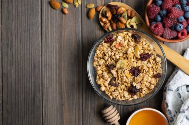 Bir cam kase fındık, bal ve çilek ile sağlıklı ev yapımı granola. Tepeüstü düz yatıyordu