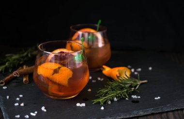 Siyah arka plan üzerinde Negroni kokteyl portakal ve biberiye bir dilim ile servis edilir. Eski kokteyl klasikleri. İtalyan aperitivo.