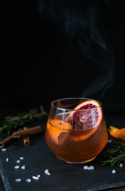 Siyah arka plan üzerinde Negroni kokteyl portakal ve biberiye bir dilim ile servis edilir. Eski kokteyl klasikleri. İtalyan aperitivo.