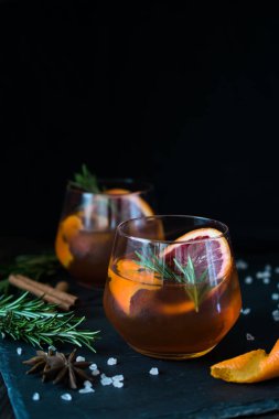 Siyah arka plan üzerinde Negroni kokteyl portakal ve biberiye bir dilim ile servis edilir. Eski kokteyl klasikleri. İtalyan aperitivo.