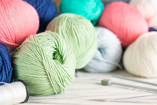 Breien hobby compositie met kleurrijke garen ballen en naalden op witte houten achtergrond. Sluiten. — Stockfoto