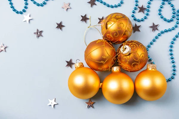 Concepto de árbol de Navidad, hecho de bolas brillantes doradas sobre fondo azul con estrellas de plata — Foto de Stock