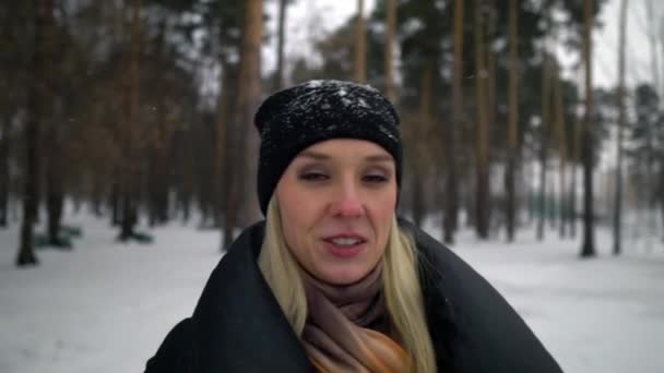 Gelukkig meisje in zwarte bontjas blazen op sneeuw in het Park. Wintervakantie. Portret van gelukkig meisje in winter Park, ze speelt met sneeuw. — Stockvideo