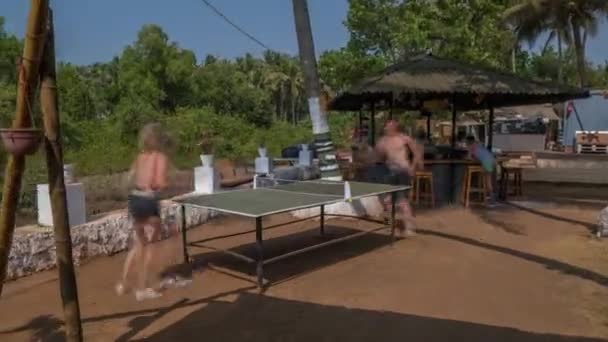 Junge Leute spielen im Urlaub am Meer Tischtennis — Stockvideo