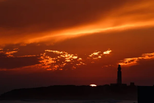 Phare avec coucher de soleil coloré avec soleil sur skyline — Photo