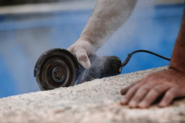 Radyal testereli işçi, havada toz ve mavi arkaplan