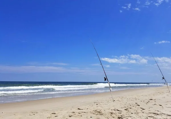 Surf fishing rods on the sandy beach on a sunny day