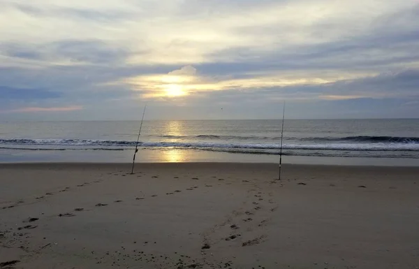 Surf fishing rods on the sandy beach on an early morning