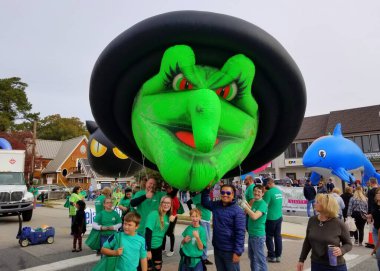 Rehoboth Sahili, Delaware, ABD - 26 Ekim 2019 - Deniz Cadısı Festivali geçit töreninde yeşil bir cadı ve sokaktaki yürüyüşçüler