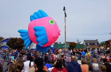 Rehoboth Beach, Delaware, ABD - 26 Ekim 2019 - Deniz Cadıları Festivali geçit töreninde büyük pembe ve mavi bir balık geçidi ve sokaktaki izleyiciler