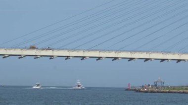 Bethany Sahili, Delaware, ABD - 28 Haziran 2020 Hint Nehri Köprüsü 'nün altındaki dalgalı akıntıdan geçen balıkçı tekneleri