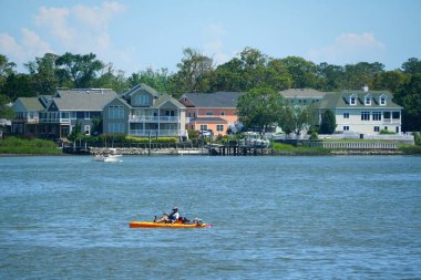 Virginia Plajı, ABD - 30 Haziran 2020 - Sahil evleri manzarası ve sıcak bir yaz gününde Baykuş Deresi 'nde bir kano
