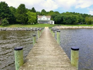 Rock Point, Maryland, ABD yakınlarındaki körfezde ahşap güverteli bir deniz evi.