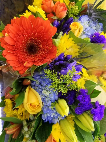 A mixed of orange daisy, blue carnation and yellow chrysanthemum flowers