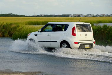 Bethany Sahili, Delaware, ABD - 1 Ekim 2020 - Sel basmış yoldan geçen beyaz bir Kia Soul