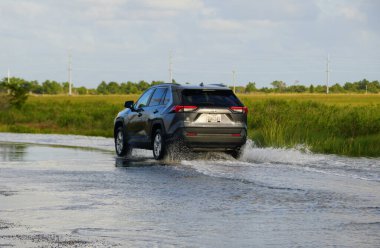 Bethany Beach, Delaware, ABD - 1 Ekim 2020 - Siyah bir Toyota RAV4 SUV sel basmış yoldan geçiyor