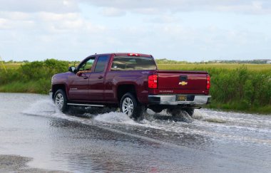 Bethany Plajı, Delaware, ABD - 1 Ekim 2020 - Su basmış yoldan geçen kırmızı bir Chevy Silverado kamyonu