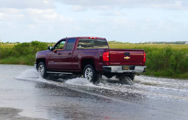 Bethany Plajı, Delaware, ABD - 1 Ekim 2020 - Su basmış yoldan geçen kırmızı bir Chevy Silverado kamyonu