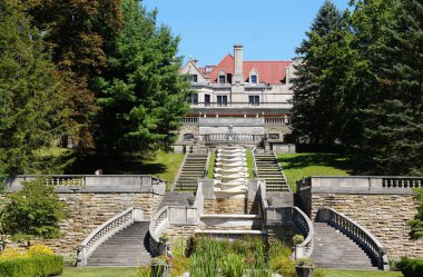 Loretto, Pennsylvania, ABD - 9 Ağustos 2025 - Kireçtaşı Şatosu, Asya Dağı 'ndaki yemyeşil ağaçların çerçevelediği çağlayan su ve katmanlı merdivenleri gözden geçirir