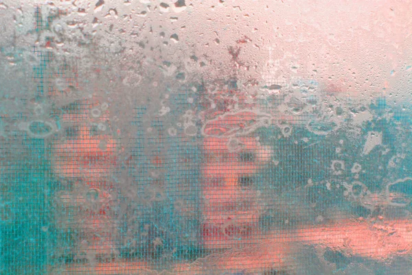 an abstraction with a wet  glass and a house on the background