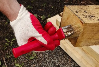 ahşap boyama işlemi, bir fırça ile eldiven eller