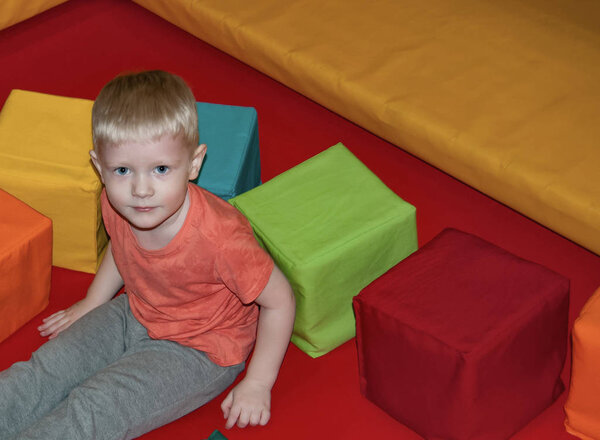 мальчик в батуте парк с яркими разноцветными кубиками
