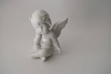 beyaz bir arka planda yanan mumlar ile melek rakam