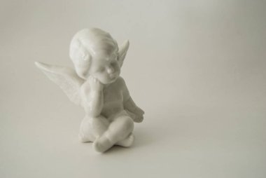 beyaz bir arka planda yanan mumlar ile melek rakam