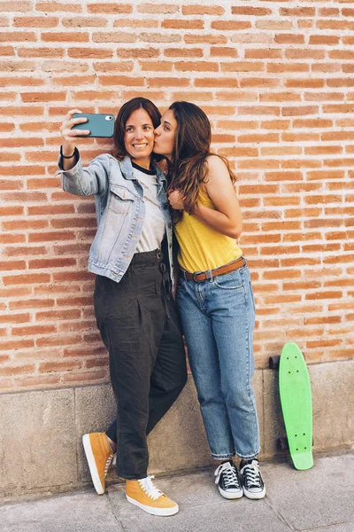 Two women kissing and making selfie. Tolerance and same sex relationship concept.