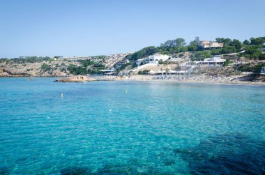 Turkuaz deniz suyunda kayalarla Cala Tarida manzarası, Ibiza adası, İspanya
