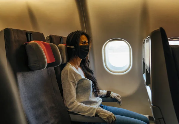 Woman in a airplane with face mask protection, coronavirus COVID19 virus