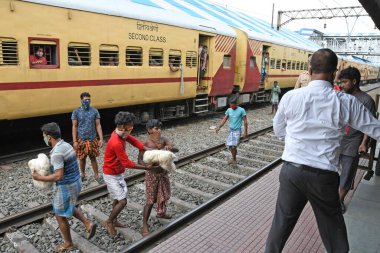 Burdwan, Batı Bengal / Hindistan - 30.05.2020: COVID-19 durumunun ortaya çıkmasından dolayı diğer eyaletlerde mahsur kalan göçmen işçiler evlerine dönerken demiryolu bölümü tarafından ücretsiz yiyecek veriliyor. Burdwan Junction Tren İstasyonunda.