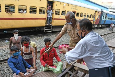 Burdwan, Batı Bengal / Hindistan - 30.05.2020: COVID-19 durumunun ortaya çıkmasından dolayı diğer eyaletlerde mahsur kalan göçmen işçiler evlerine dönerken demiryolu bölümü tarafından ücretsiz yiyecek veriliyor. Burdwan Junction Tren İstasyonunda.