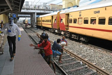 Burdwan, Batı Bengal / Hindistan - 30.05.2020: COVID-19 durumunun ortaya çıkmasından dolayı diğer eyaletlerde mahsur kalan göçmen işçiler evlerine dönerken demiryolu bölümü tarafından ücretsiz yiyecek veriliyor. Burdwan Junction Tren İstasyonunda.