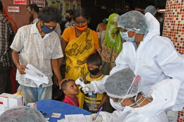 Burdwan Town, Purba Bardhaman, Batı Bengal / Hindistan - 29.05.2020: Diğer eyaletlerden gelen 'Shramik Special' treniyle memleketlerine dönen göçmen işçiler Roman Coronavirus (COVID-19) için sağlık taraması yapılıyor. 