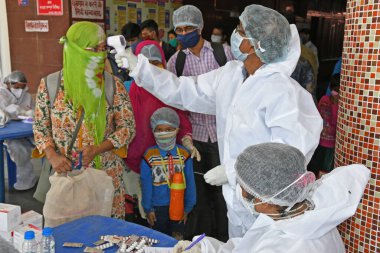 Burdwan Town, Purba Bardhaman, Batı Bengal / Hindistan - 29.05.2020: Diğer eyaletlerden gelen 'Shramik Special' treniyle memleketlerine dönen göçmen işçiler Roman Coronavirus (COVID-19) için sağlık taraması yapılıyor. 