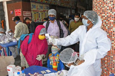 Burdwan Town, Purba Bardhaman, Batı Bengal / Hindistan - 29.05.2020: Diğer eyaletlerden gelen 'Shramik Special' treniyle memleketlerine dönen göçmen işçiler Roman Coronavirus (COVID-19) için sağlık taraması yapılıyor. 
