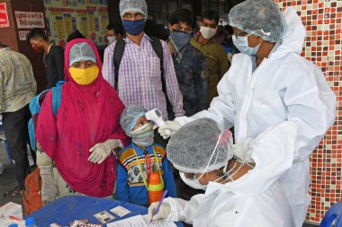 Burdwan Town, Purba Bardhaman, Batı Bengal / Hindistan - 29.05.2020: Diğer eyaletlerden gelen 'Shramik Special' treniyle memleketlerine dönen göçmen işçiler Roman Coronavirus (COVID-19) için sağlık taraması yapılıyor. 