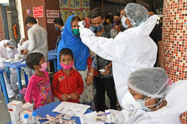 Burdwan Town, Purba Bardhaman, Batı Bengal / Hindistan - 29.05.2020: Diğer eyaletlerden gelen 'Shramik Special' treniyle memleketlerine dönen göçmen işçiler Roman Coronavirus (COVID-19) için sağlık taraması yapılıyor. 