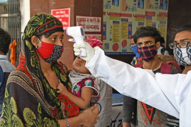 Burdwan Town, Purba Bardhaman, Batı Bengal / Hindistan - 29.05.2020: Diğer eyaletlerden gelen 'Shramik Special' treniyle memleketlerine dönen göçmen işçiler Roman Coronavirus (COVID-19) için sağlık taraması yapılıyor. 