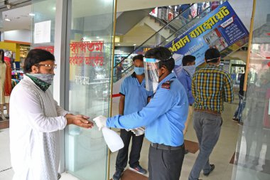 Burdwan Town, Purba Bardhaman İlçesi, Batı Bengal / Hindistan - 08.06.2020: Alıcılar, Novel Coronavirus (COVID-19) enfeksiyonunu önlemek için hijyen kurallarını (Termal Tarama ve El Temizleme) izledikten sonra alışveriş merkezlerine giriyorlar.