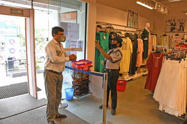 Burdwan Town, Purba Bardhaman İlçesi, Batı Bengal / Hindistan - 08.06.2020: Alıcılar, Novel Coronavirus (COVID-19) enfeksiyonunu önlemek için hijyen kurallarını (Termal Tarama ve El Temizleme) izledikten sonra alışveriş merkezlerine giriyorlar.