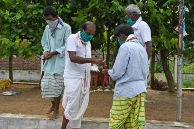 Burdwan, Purba Bardhaman Bölgesi, Batı Bengal / Hindistan - 27.07.2020: Santal cemaati tüm dünyadaki insanları Novel Coronavirus 'tan (COVID-19) kurtarmak için dini törenler yoluyla dua etti. Burdwan 'daki Bamchandaipur köyünde.