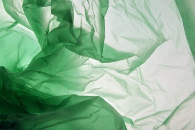 Plastik torba konsepti. Polietilen arka plan olarak kullanabilirsiniz. Yeşilin farklı tonlarındaki plastik. Tasarım için arka plan. Kart, poster, afiş tasarımı için şablon. Renkli doku.