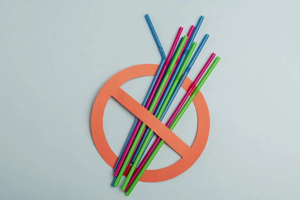 Açık yeşil arka planda plastik pipetler ile kırmızı kullanım sembolü yok. Çevre kavramı. Ban tek kullanımlık plastik. Metin için alan kopyalama.