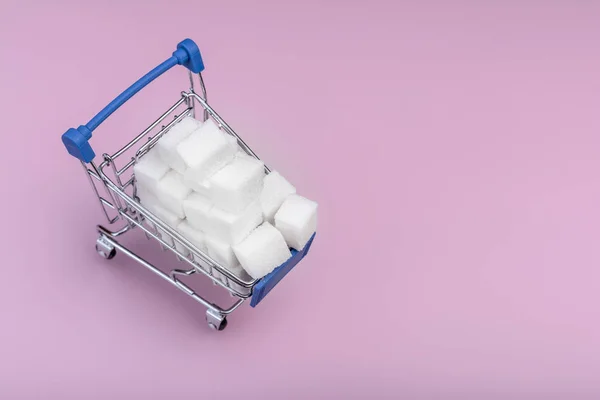 Koncepcja kostek cukru. Biały cukier kostki w koszyku na różowym. Kopiuj miejsce dla tekstu. — Zdjęcie stockowe