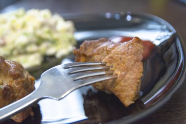 Masada bir tabak kızarmış pirzola ve salata var. Lezzetli ve sağlıklı bir öğle yemeği. Lezzetli barbekü kavramı.